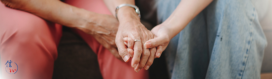 Holding hands to show support during a Buddhist funeral.
