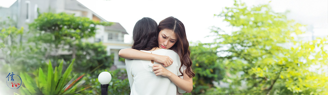 Hugging a grieving friend during a Taoist funeral service.